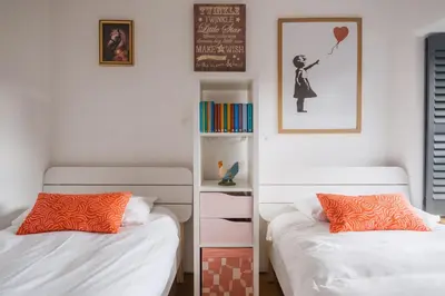 a bedroom with two beds and a book shelf at The Farmhouse in Porth
