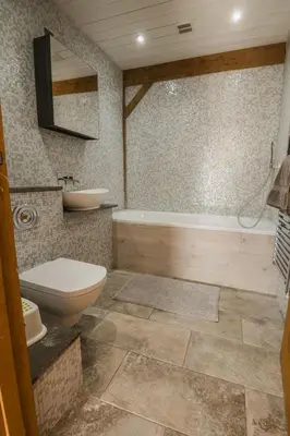 a bathroom with a tub and a toilet and a sink at The Farmhouse in Porth