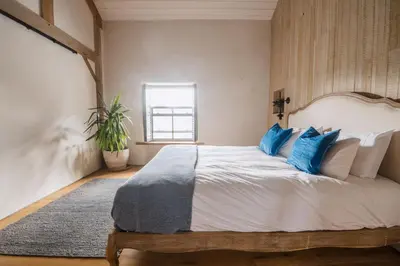 a bedroom with a large bed with blue pillows at The Farmhouse in Porth