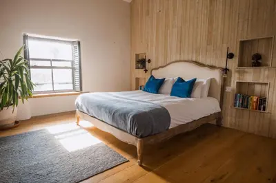 a bedroom with a large bed with blue pillows at The Farmhouse in Porth