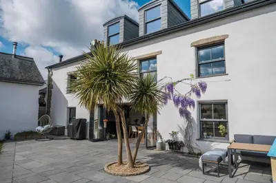 a palm tree in front of a white house at The Farmhouse in Porth