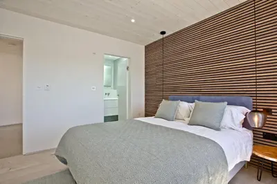 a bedroom with a large bed and a wooden wall at Rockpools in Porth
