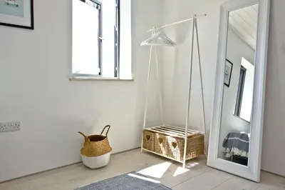 a dressing room with a mirror and a basket at Rockpools in Porth