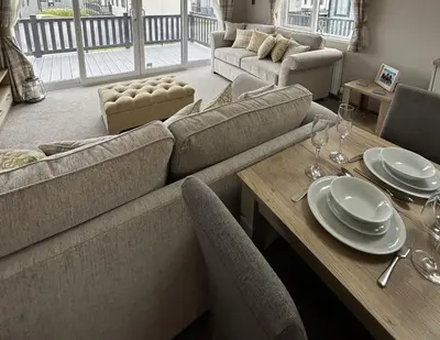 a living room with a couch and a table with chairs at Sandy Toes, Padstow in Padstow