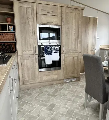 a kitchen with wooden cabinets and an oven at Sandy Toes, Padstow in Padstow