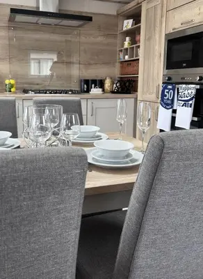 a table with wine glasses and plates on it at Sandy Toes, Padstow in Padstow