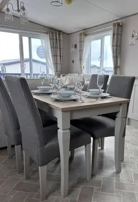 a dining room table with chairs and wine glasses on it at Sandy Toes, Padstow in Padstow