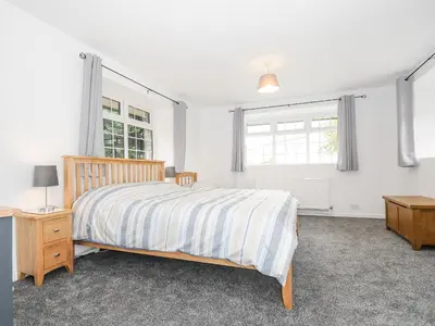 a white bedroom with a bed and a window at The Old Forge in Saltash
