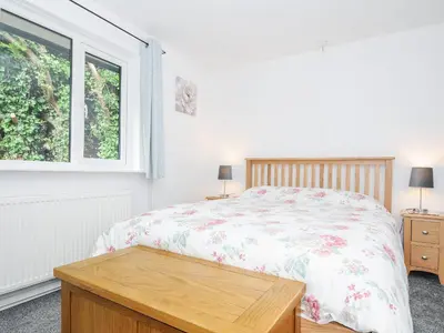 a bedroom with a bed and a window at The Old Forge in Saltash