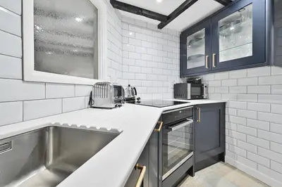 a kitchen with blue cabinets and a sink at Luxury Couple's Getaway with River Views and Parking in Polperro