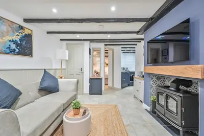a living room with a couch and a stove at Luxury Couple's Getaway with River Views and Parking in Polperro