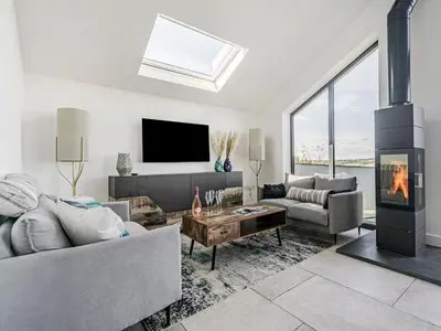a living room with a couch and a fireplace at The Old Coach Garage in Gerrans