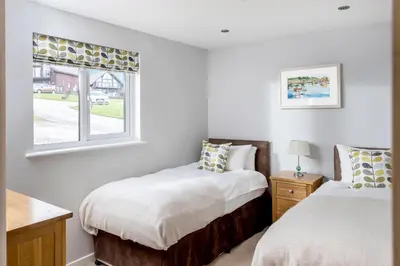 two beds in a room with a window at Sunbow at Retallack Resort in Saint Columb Major