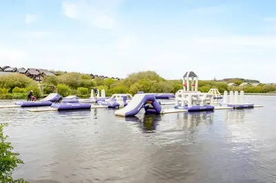 a water park with a water slide in the water at Sunbow at Retallack Resort in Saint Columb Major