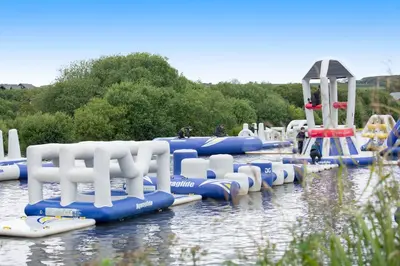 a row of blue and white rafts in the water at Sunbow at Retallack Resort in Saint Columb Major