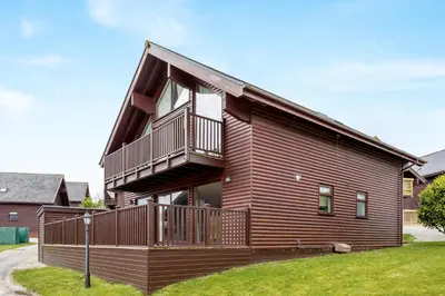 a house with a large deck on the side of it at Sunbow at Retallack Resort in Saint Columb Major