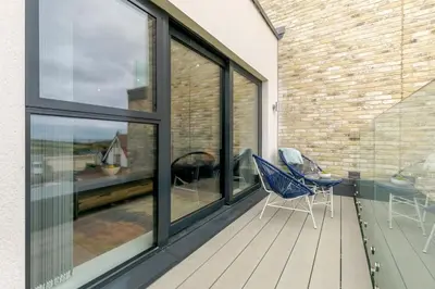 a balcony with two chairs and a table and windows at 2 Bed in Newquay oc-e26943 in Newquay