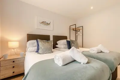 two twin beds in a bedroom with a dresser at 2 Bed in Newquay oc-e26943 in Newquay