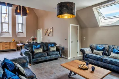 a living room with blue couches and a table at Finest Retreats - Beach House in Newquay