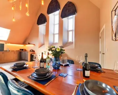 a dining room table with wine bottles and glasses at Finest Retreats - Beach House in Newquay