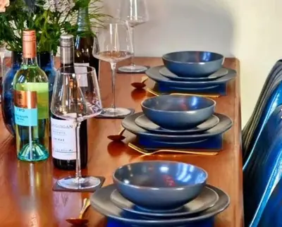 a wooden table with bowls and bottles of wine at Finest Retreats - Beach House in Newquay