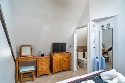 a bedroom with a bed and a tv and a mirror at Finest Retreats - Lobster House in Newquay