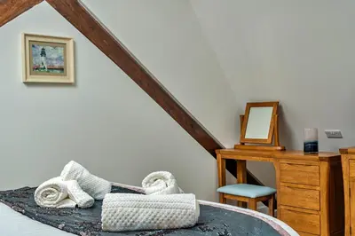 a bedroom with a bed with a desk and a mirror at Finest Retreats - Lobster House in Newquay
