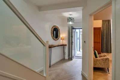 a staircase in a home with a mirror and a chair at Finest Retreats - Lobster House in Newquay