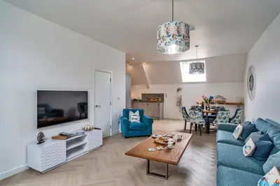 a living room with a blue couch and a tv at Finest Retreats - Lobster House in Newquay