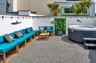 a patio with blue couches and a hot tub at Finest Retreats - Lobster House in Newquay