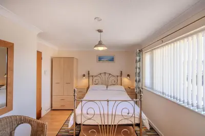 a bedroom with a bed and a window at Mermaid - Pet Friendly Self Catering Holiday Cottage Hayle in Hayle