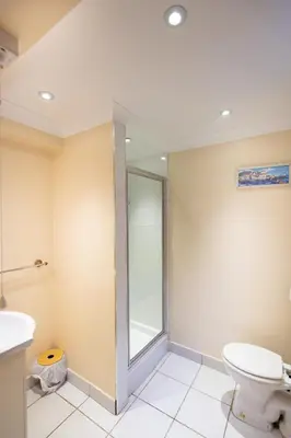 a bathroom with a toilet and a glass shower at Mermaid - Pet Friendly Self Catering Holiday Cottage Hayle in Hayle