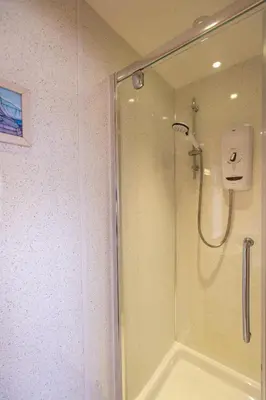 a shower with a glass door in a bathroom at Mermaid - Pet Friendly Self Catering Holiday Cottage Hayle in Hayle