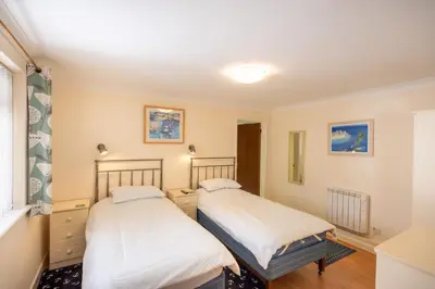 two beds in a room with a window at Mermaid - Pet Friendly Self Catering Holiday Cottage Hayle in Hayle