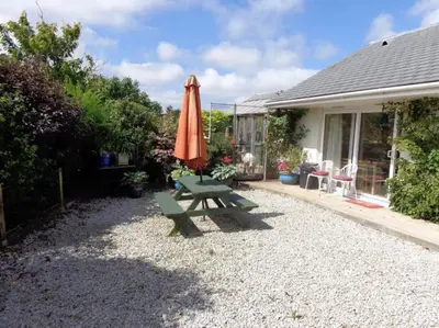 an orange umbrella and a picnic table with an umbrella at Wadebridge Whitecross Studio 2 in Wadebridge