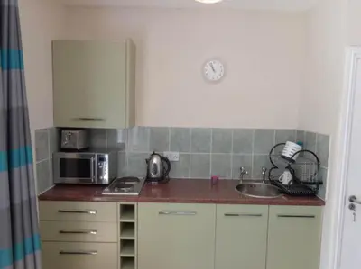 a kitchen with a sink and a microwave at Wadebridge Whitecross Studio 2 in Wadebridge
