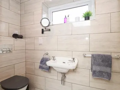 a bathroom with a sink and a toilet and a mirror at Chi an Mor in Penzance