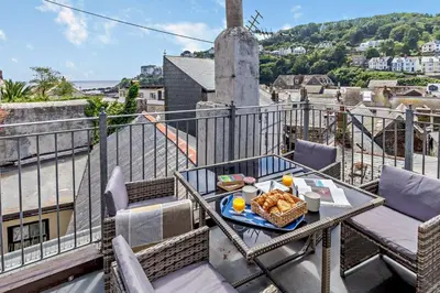 a table with a plate of food on a balcony at 2 Bed in Looe oc-b27563 in Looe