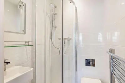 a white bathroom with a shower and a sink at 2 Bed in Looe oc-b27563 in Looe