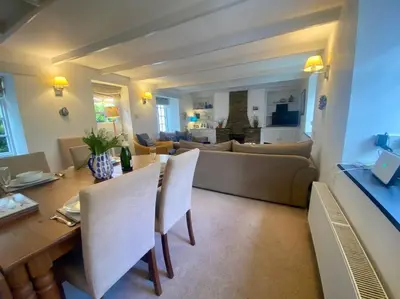 a living room with a couch and a table and chairs at Brook Cottage is a traditional fisherman's cottage in Port Isaac