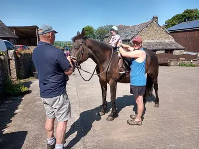 a man standing next to a man holding a horse at Fentrigan Manor Farm & Holiday Cottages in Bude