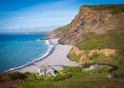 a house on a hill next to the ocean at Fentrigan Manor Farm & Holiday Cottages in Bude