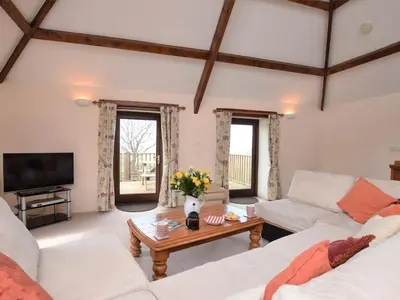 a living room with two white couches and a table at Fentrigan Manor Farm & Holiday Cottages in Bude