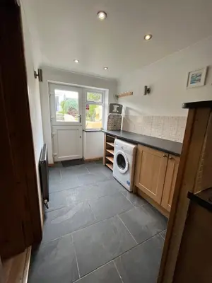 a kitchen with a washer and dryer in a room at Pet friendly cottage in Pool
