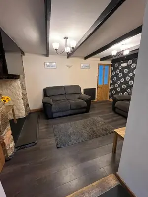 a living room with a couch and a table at Pet friendly cottage in Pool