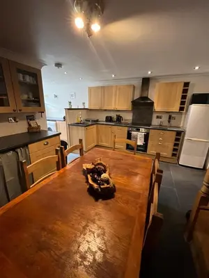 a large kitchen with a wooden table in a room at Pet friendly cottage in Pool