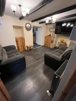 a living room with two couches and a tv at Pet friendly cottage in Pool