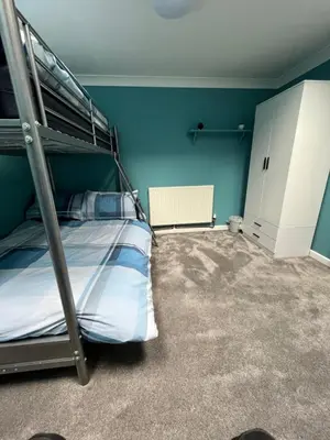 a bedroom with a bunk bed and blue walls at Pet friendly cottage in Pool