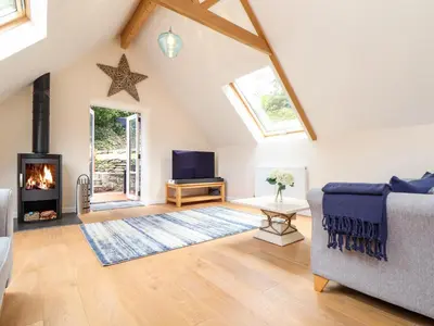 a living room with a couch and a fireplace at Potters Barn in Helston