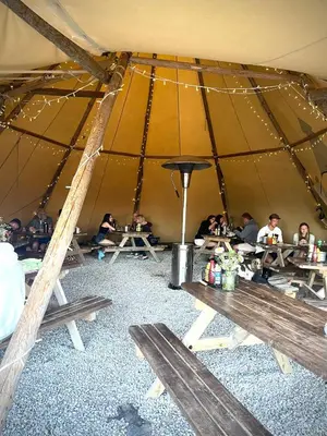 a group of people sitting at tables in a tent at Stones Throw Lodge in Padstow